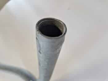 Nahaufnahme des oberen Endes eines Schleppstativ RE210-Metallrohrs mit Innengewinde vor einem schlichten hellen Hintergrund.