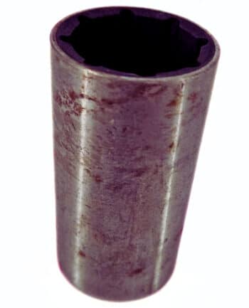 Eine Nahaufnahme der Büchse mit Gummi 100/27, einem zylindrischen Metallwerkzeug mit einer dunklen Sechskantöffnung an der Spitze.