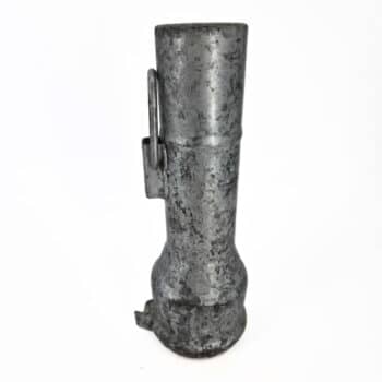 Eine verwitterte, zylindrische Erweiterung mit Schlaufenverschluss 80 (Schlaufe) auf 100 (Nase) zeichnet sich durch eine unregelmäßige Oberfläche, ein vorstehendes Seitenteil und einen ausgestellten Sockel aus, der vor einem schlichten weißen Hintergrund steht.