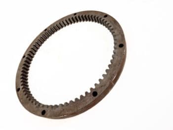 Der "Zahnkranz für JD 4 Zylinder" ist ein kreisförmiger Metallzahnkranz mit Innenverzahnung und gleichmäßig verteilten Löchern am äußeren Rand, der auf weißem Grund abgebildet ist.