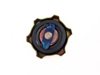 Eine Nahaufnahme des Motorölverschlusses, eines runden Metallgegenstands mit sternförmigem Rand und blauem Verschluss in der Mitte, vor weißem Hintergrund.