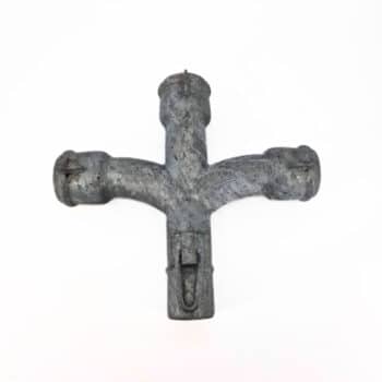 Eine Vierwegeabweichung aus Metall mit Schlaufenverschluss, die drei T-förmige Öffnungen aufweist, fotografiert vor einem schlichten weißen Hintergrund.