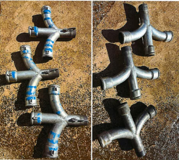 Sechs Beschläge "Vier Wege Abzweiger DM100" mit blauen Markierungen sind in zwei Dreiergruppen auf einer rauen, sonnenbeschienenen Fläche angeordnet.