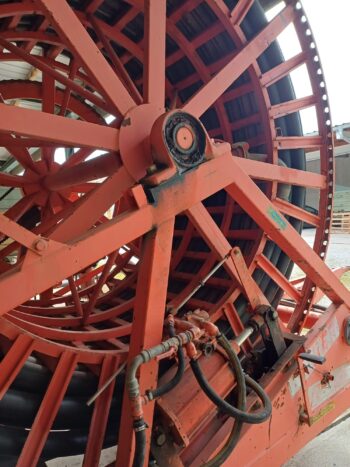 Nahaufnahme eines Rainstar Typ 82-360 S, eines großen roten Industrie-Schlauchaufrollers mit Hydraulikkomponenten, der in einem überdachten Außenbereich steht.