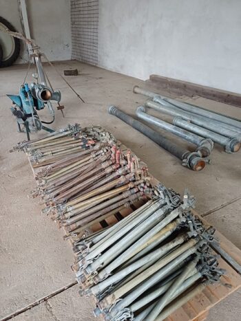 Vielfalt an Beregnungsteilen sind auf dem Boden eines Betonraums angeordnet, im Hintergrund ist Maschinenbau sichtbar.