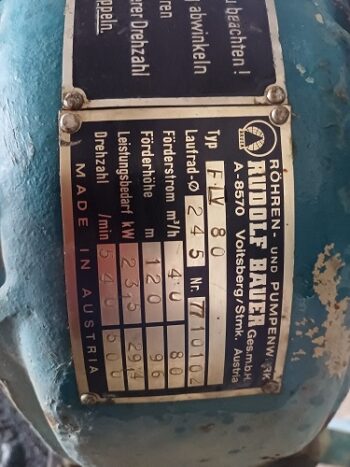 Nahaufnahme eines Metallschilds an einer Maschine mit deutschem Text, der technische Daten und Herstellerangaben für Vielfalt an Beregnungsteilen enthält, darunter Angaben wie "Rudolf Bauer" und "Made in Austria".