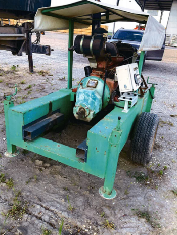 Ein COGEM Aggregat 80 PS, eine grüne Industriemaschine auf Rädern mit Motor, Schaltkasten und Schutzdach, steht im Freien auf dem Boden neben anderen Fahrzeugen.