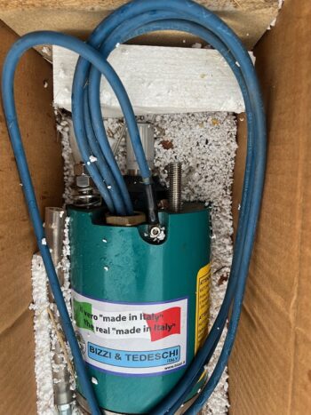 Ein elektrischer Tauchmotor 30 kW von BIZZI TEDESCHI mit einem grünen Motorteil und blauen Kabeln ist in einem Karton mit weißem Schaumstoff und Verpackungschips verpackt.